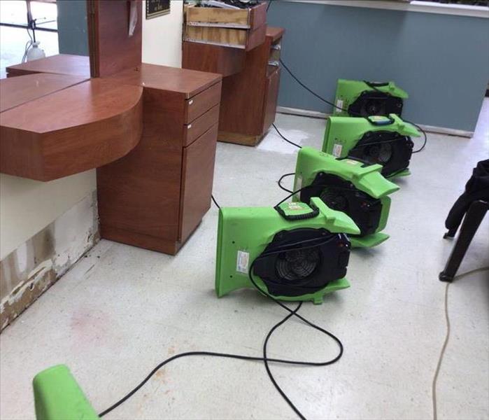 Air movers drying a wall.
